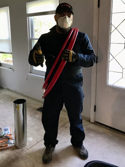 Kyle in a face mask, gloves, and jumpsuit